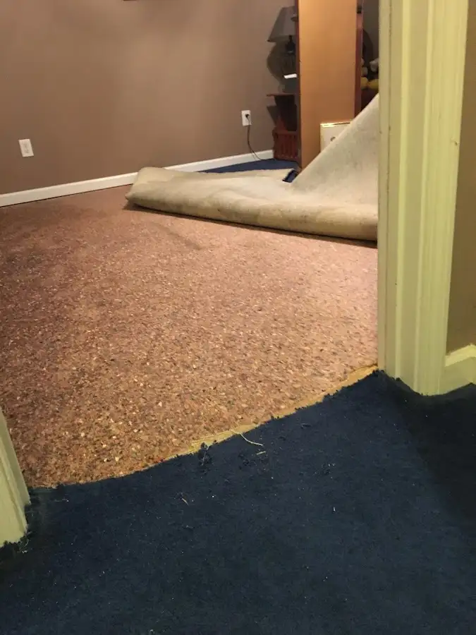 Carpet pad removal revealing water damage during Water Mitigation Services in Dakota Dunes